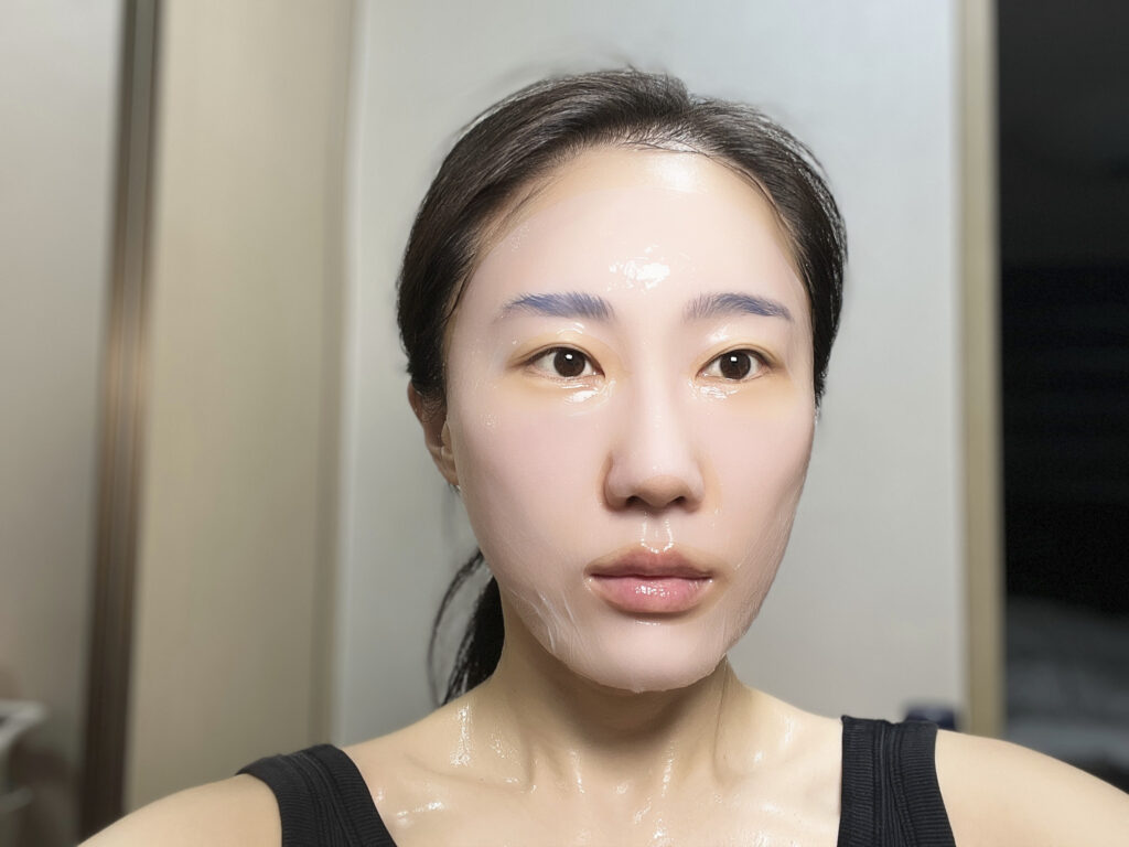 Wearing the LA MUSE sheet mask, front view, essence fully saturating the skin
