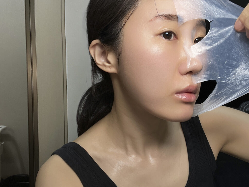 Peeling off the LA MUSE sheet mask after use, close-up on the cheek