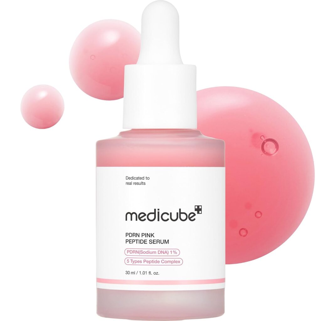 Medicube PDRN Pink Peptide Serum bottle with pink liquid texture droplets.